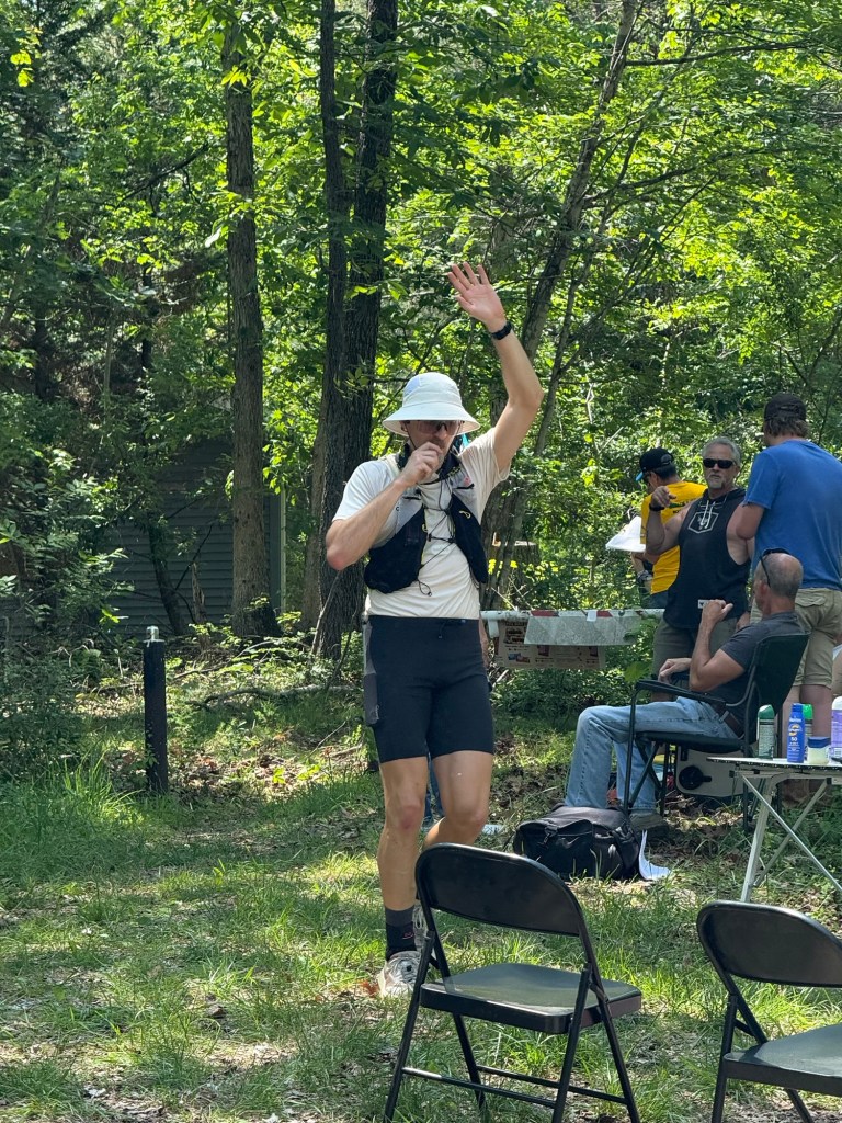 Patrick enthusiastically greeting his crew at Shawl Gap aid station while wearing a bucket hat.